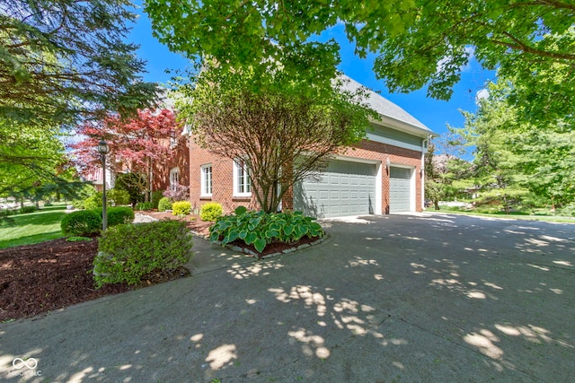 view of home's exterior with brick siding, driveway, and a garage