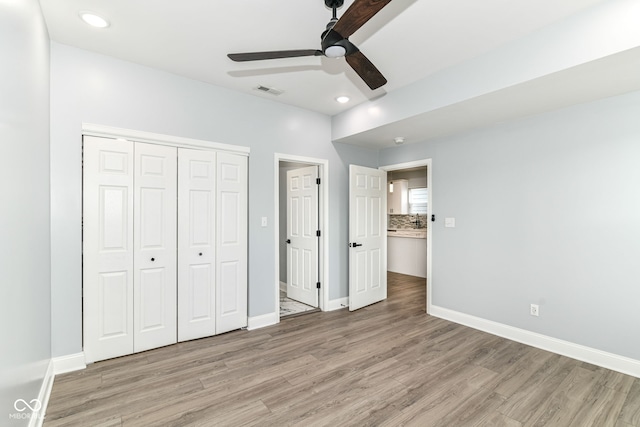 unfurnished bedroom featuring light wood-style flooring, a closet, recessed lighting, baseboards, and a ceiling fan