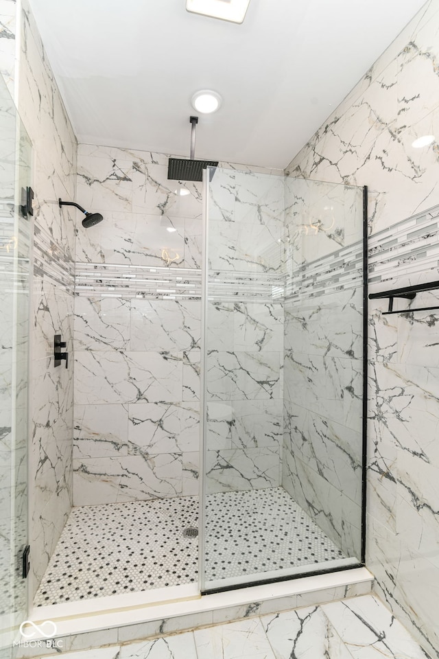 full bathroom with a marble finish shower and marble finish flooring