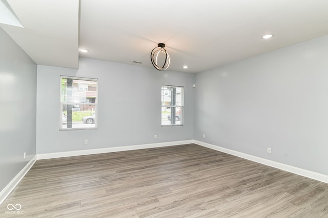 empty room with wood finished floors, recessed lighting, and baseboards