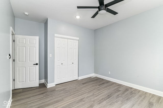 unfurnished bedroom featuring wood finished floors, a closet, baseboards, recessed lighting, and a ceiling fan