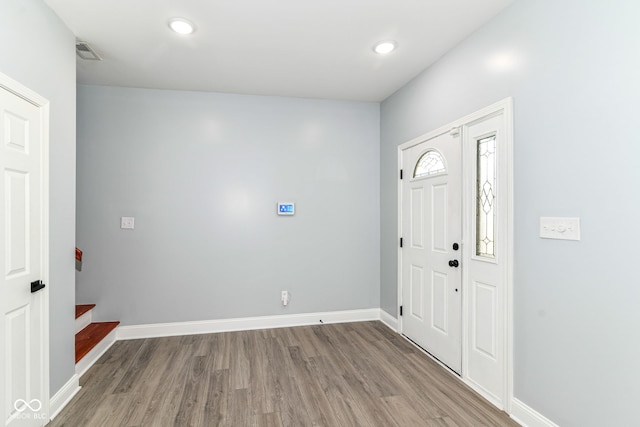 foyer featuring wood finished floors, baseboards, and recessed lighting