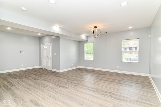 unfurnished room with recessed lighting, baseboards, light wood finished floors, and a smoke detector