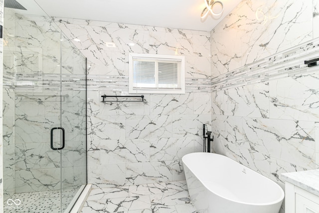 full bath with a marble finish shower, a freestanding tub, marble tiled flooring, and tile walls