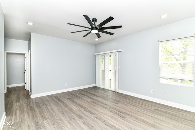 spare room with healthy amount of natural light, wood finished floors, ceiling fan, baseboards, and recessed lighting