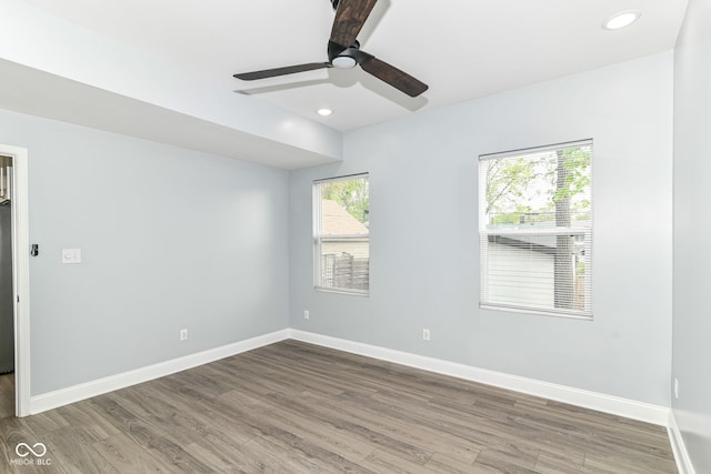 spare room featuring wood finished floors, a ceiling fan, baseboards, and recessed lighting