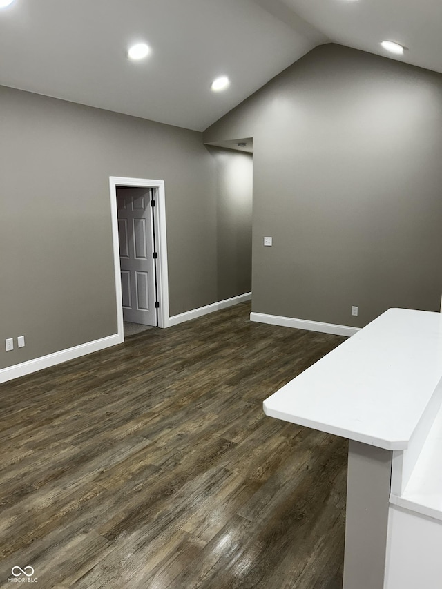 336 W 29th St, Indianapolis, IN 46208 - unfurnished living room featuring baseboards, recessed lighting, dark wood-style floors, and vaulted ceiling