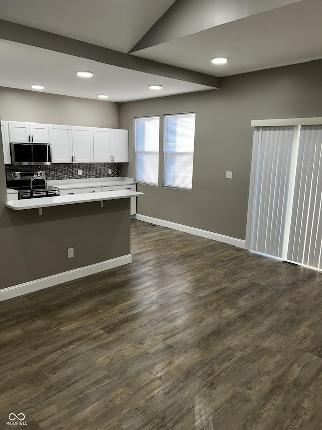 336 W 29th St, Indianapolis, IN 46208 - kitchen featuring appliances with stainless steel finishes, light countertops, white cabinetry, backsplash, and dark wood-type flooring