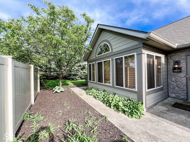 16657 Brownstone Ct, Westfield, IN 46074 - view of side of property with stone siding, fence, and a shingled roof