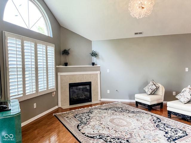 16657 Brownstone Ct, Westfield, IN 46074 - living room featuring vaulted ceiling, a tiled fireplace, wood finished floors, baseboards, and a chandelier