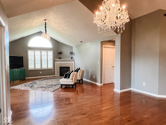 16657 Brownstone Ct, Westfield, IN 46074 - living area with lofted ceiling, wood finished floors, baseboards, a chandelier, and a glass covered fireplace