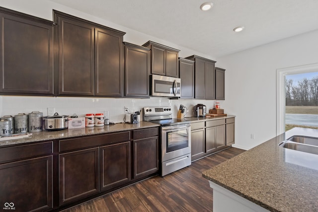 6903 Aster Dr, Pendleton, IN 46064 - kitchen featuring appliances with stainless steel finishes, dark wood finished floors, tasteful backsplash, stone countertops, and recessed lighting