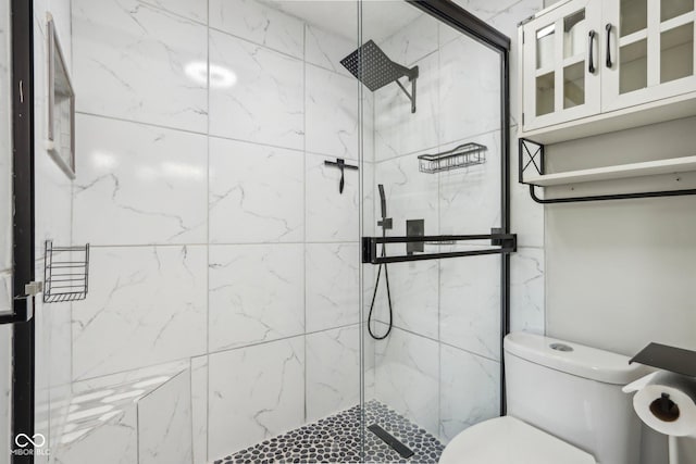 bathroom featuring a marble finish shower and toilet