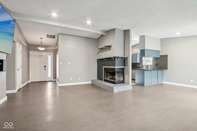 unfurnished living room featuring baseboards, recessed lighting, a brick fireplace, and a sink