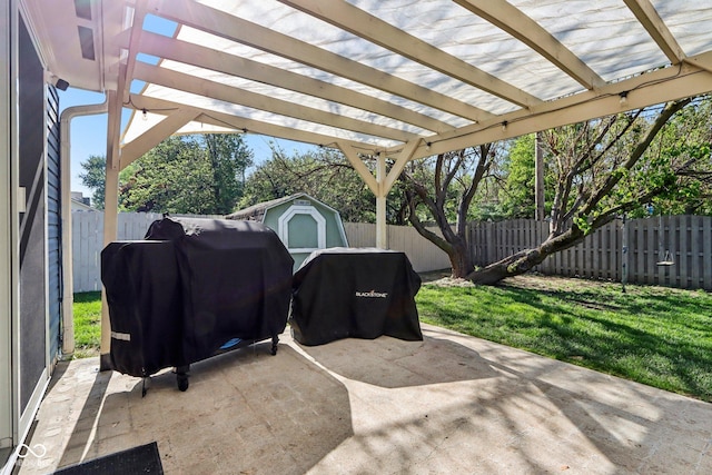 view of patio featuring a storage unit, a fenced backyard, and an outdoor structure