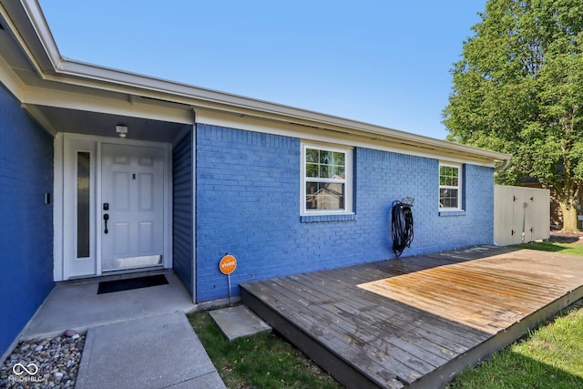 property entrance featuring brick siding and a deck