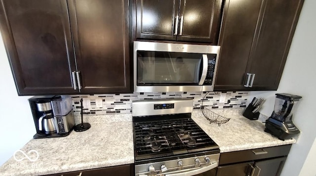 kitchen with appliances with stainless steel finishes, dark brown cabinetry, and backsplash