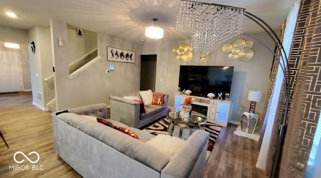 living area with stairs, wood finished floors, and baseboards