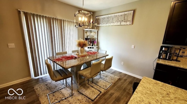 dining room featuring baseboards, dark wood-type flooring, and a chandelier