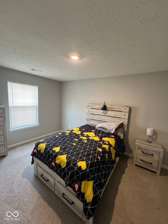 bedroom with carpet, a textured ceiling, and baseboards