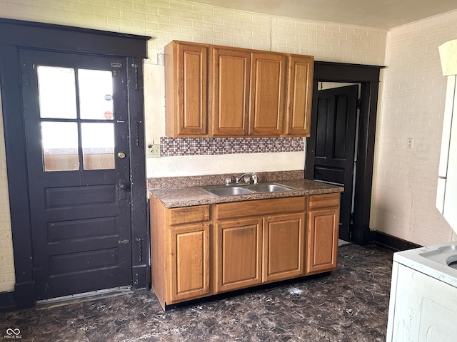 205 N Sheffield Ave, Indianapolis, IN 46222 - kitchen featuring a sink, brown cabinets, brick wall, and dark countertops