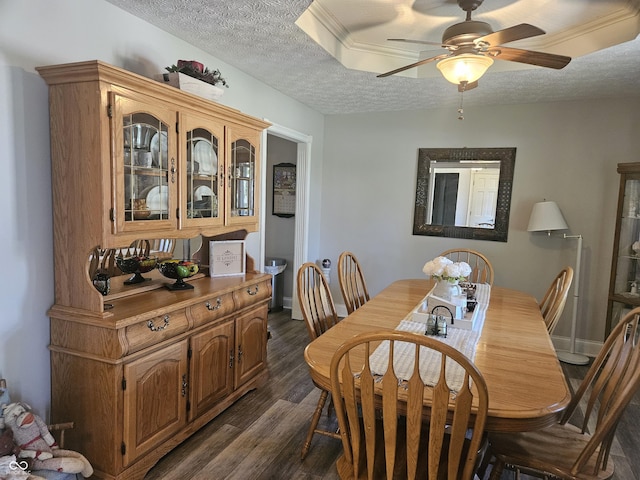 dining area with a textured ceiling, dark wood-style floors, a ceiling fan, and baseboards