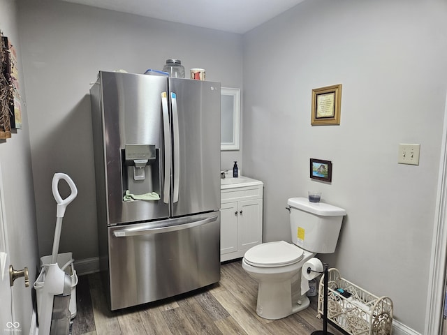 bathroom featuring wood finished floors, vanity, toilet, and baseboards
