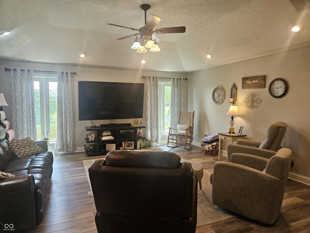living room with healthy amount of natural light, a textured ceiling, ceiling fan, lofted ceiling, and baseboards