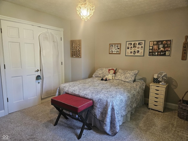 carpeted bedroom featuring a closet, a chandelier, and a textured ceiling