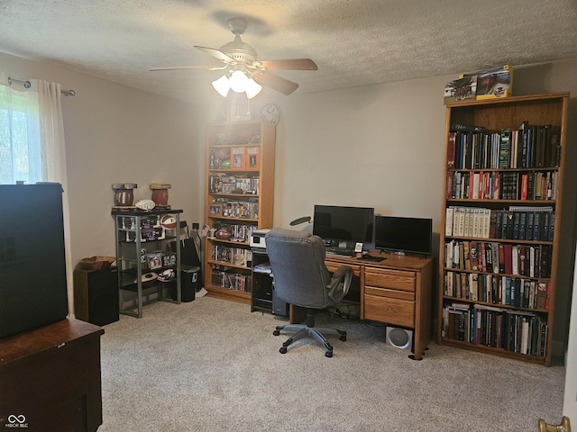 carpeted office space featuring ceiling fan and a textured ceiling