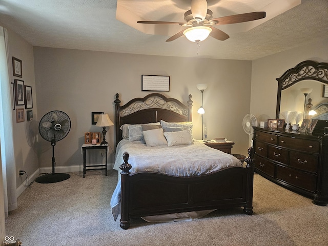 carpeted bedroom featuring a textured ceiling and a ceiling fan