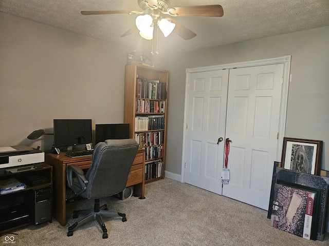 home office featuring ceiling fan, carpet flooring, and a textured ceiling