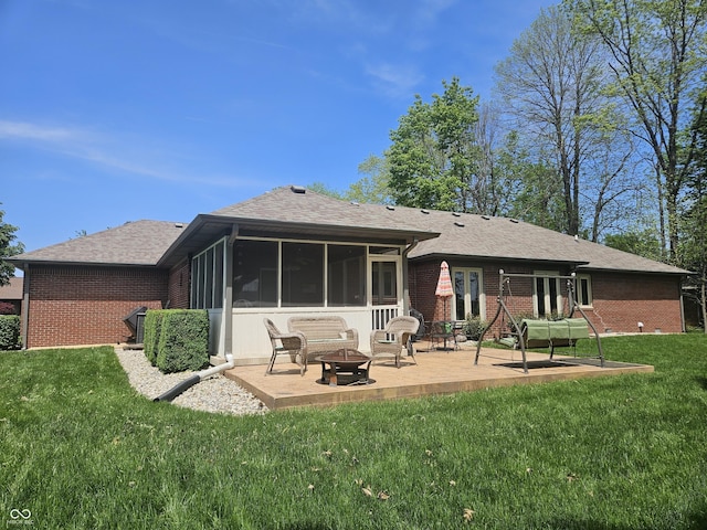 back of property with an outdoor fire pit, a patio area, a sunroom, and brick siding
