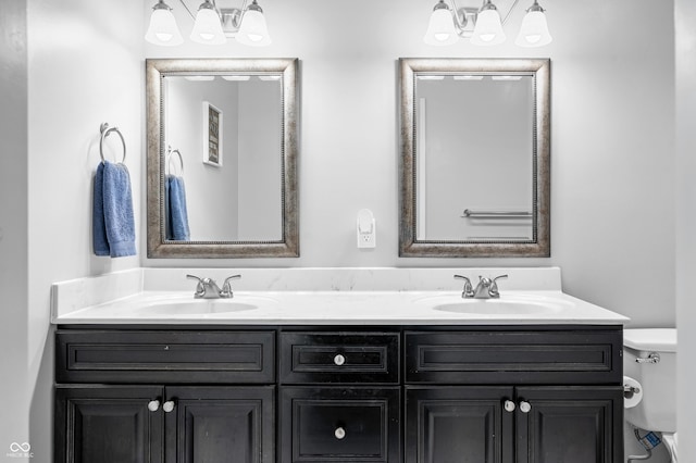 full bath featuring a chandelier, toilet, and double vanity