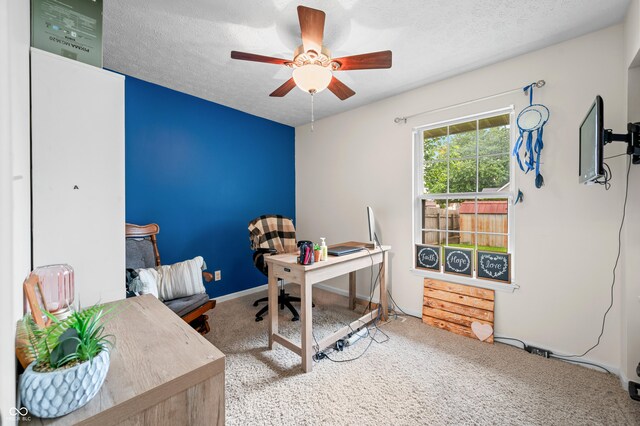 home office with carpet floors, a ceiling fan, and a textured ceiling