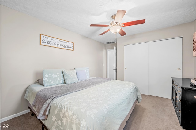 bedroom with light carpet, a closet, and a ceiling fan