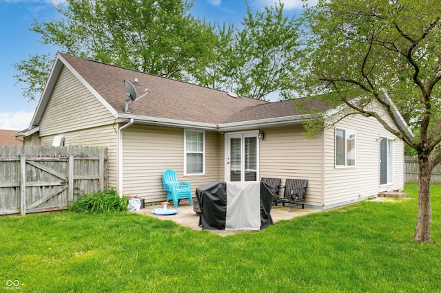 rear view of house featuring a patio and roof with shingles