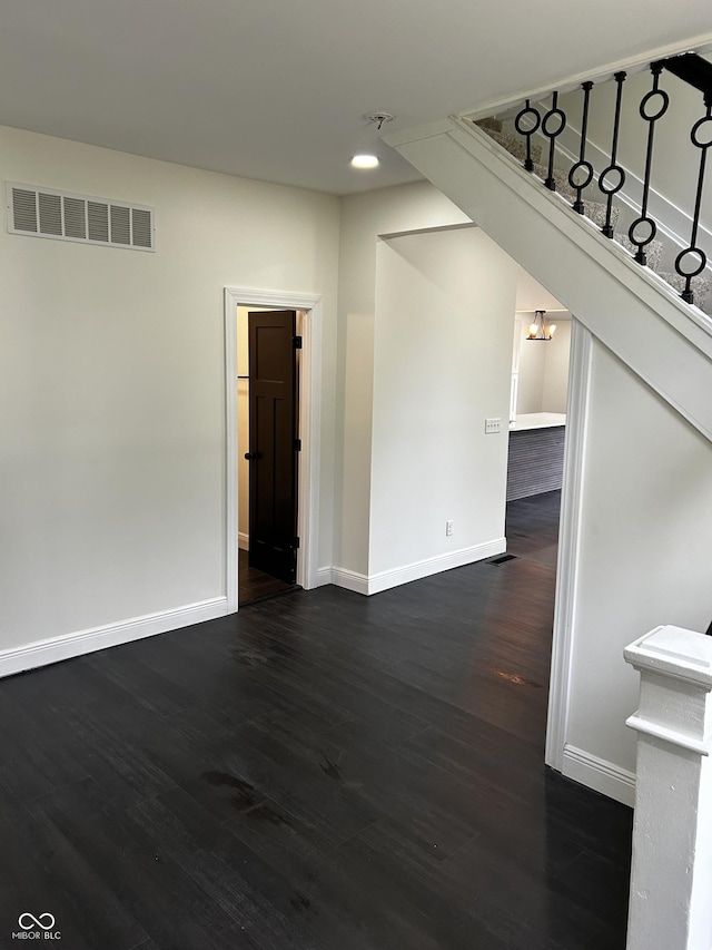 unfurnished room with baseboards, dark wood-type flooring, stairs, and recessed lighting