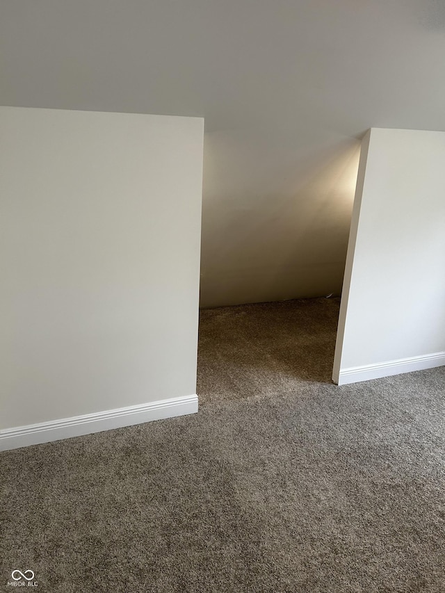 carpeted empty room featuring baseboards