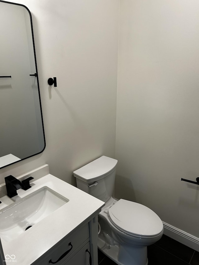 bathroom with toilet, tile patterned flooring, and vanity