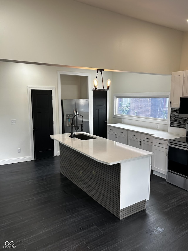 kitchen featuring stainless steel appliances, a sink, light countertops, decorative backsplash, and white cabinets