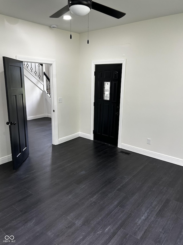 foyer entrance with a ceiling fan, dark wood finished floors, and baseboards