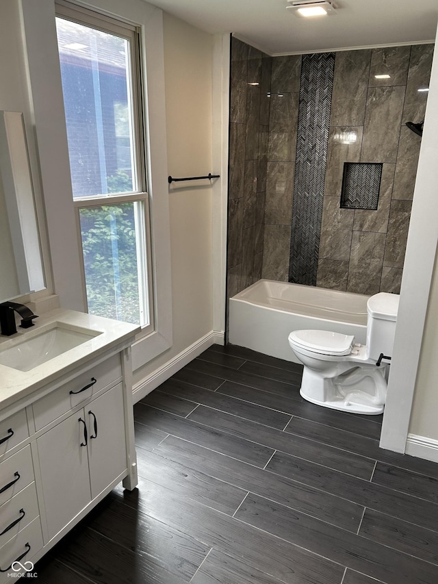 full bathroom with toilet, plenty of natural light, wood finished floors, and vanity