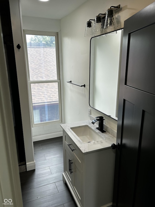 bathroom featuring wood finished floors, vanity, and baseboards