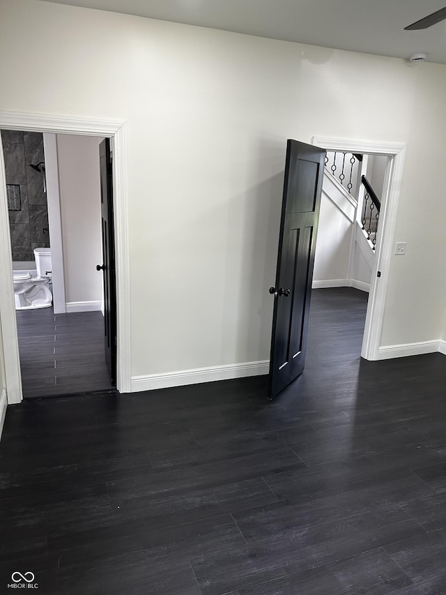 unfurnished room featuring baseboards, dark wood finished floors, stairs, and a smoke detector
