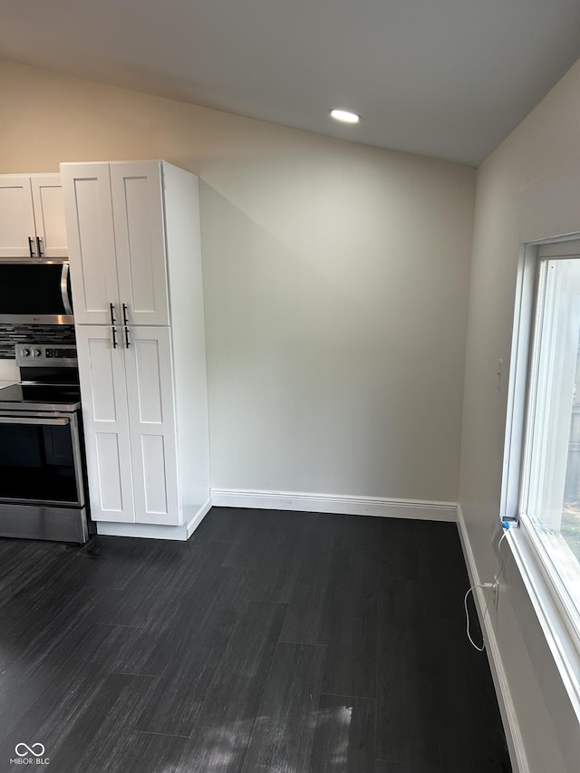 kitchen with appliances with stainless steel finishes, baseboards, dark wood-type flooring, recessed lighting, and white cabinets