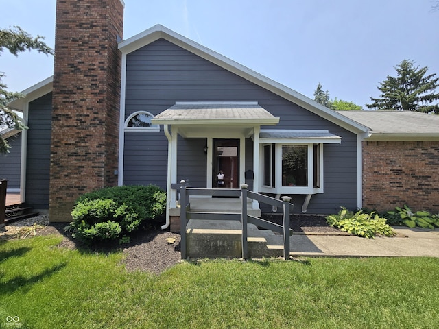 8055 Foxchase Dr, Indianapolis, IN 46256 - view of front of home with a chimney, brick siding, and a front yard