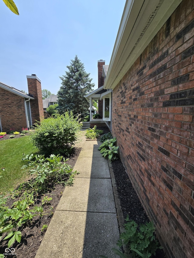 8055 Foxchase Dr, Indianapolis, IN 46256 - view of home's exterior with a chimney and brick siding