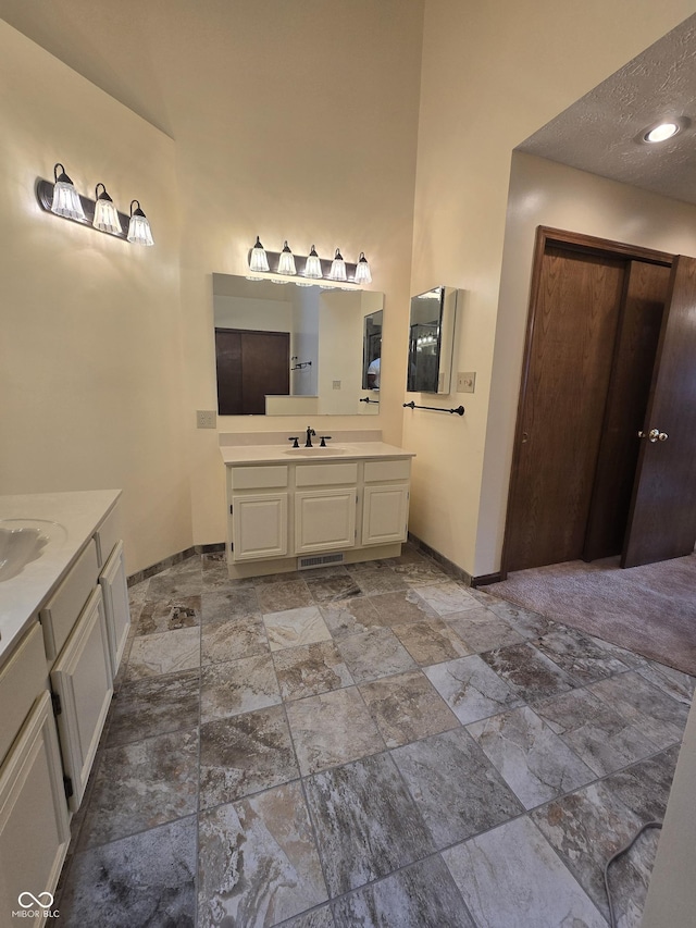 8055 Foxchase Dr, Indianapolis, IN 46256 - bathroom featuring stone finish floors, two vanities, and a towering ceiling
