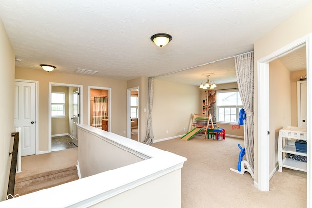 9860 Gallop Ln, Fishers, IN 46040 - hall with light colored carpet, a chandelier, and healthy amount of natural light
